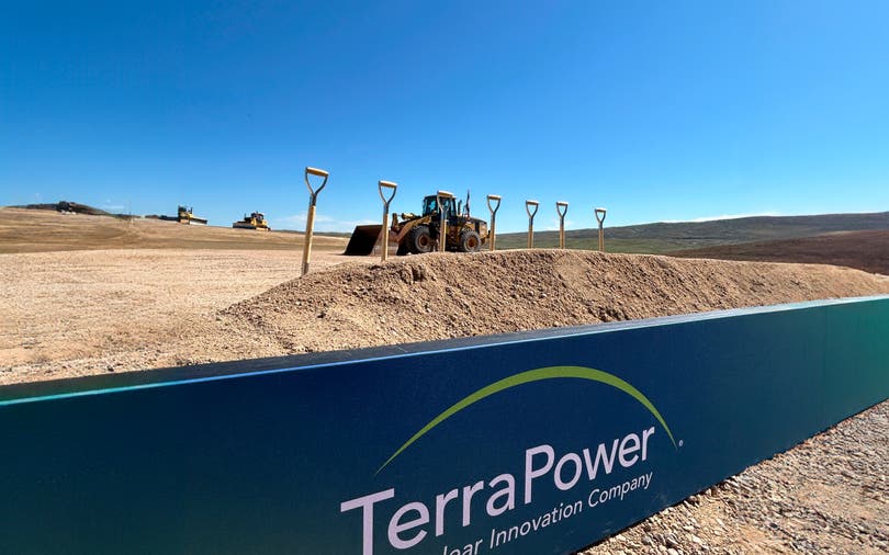 Natrium plant groundbreaking location with shovels standing in the dirt, a bulldozer in the background, and the TerraPower sign in foreground.