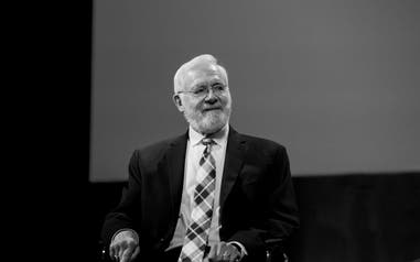 Bill Foege sitting in a chair looking to the side.