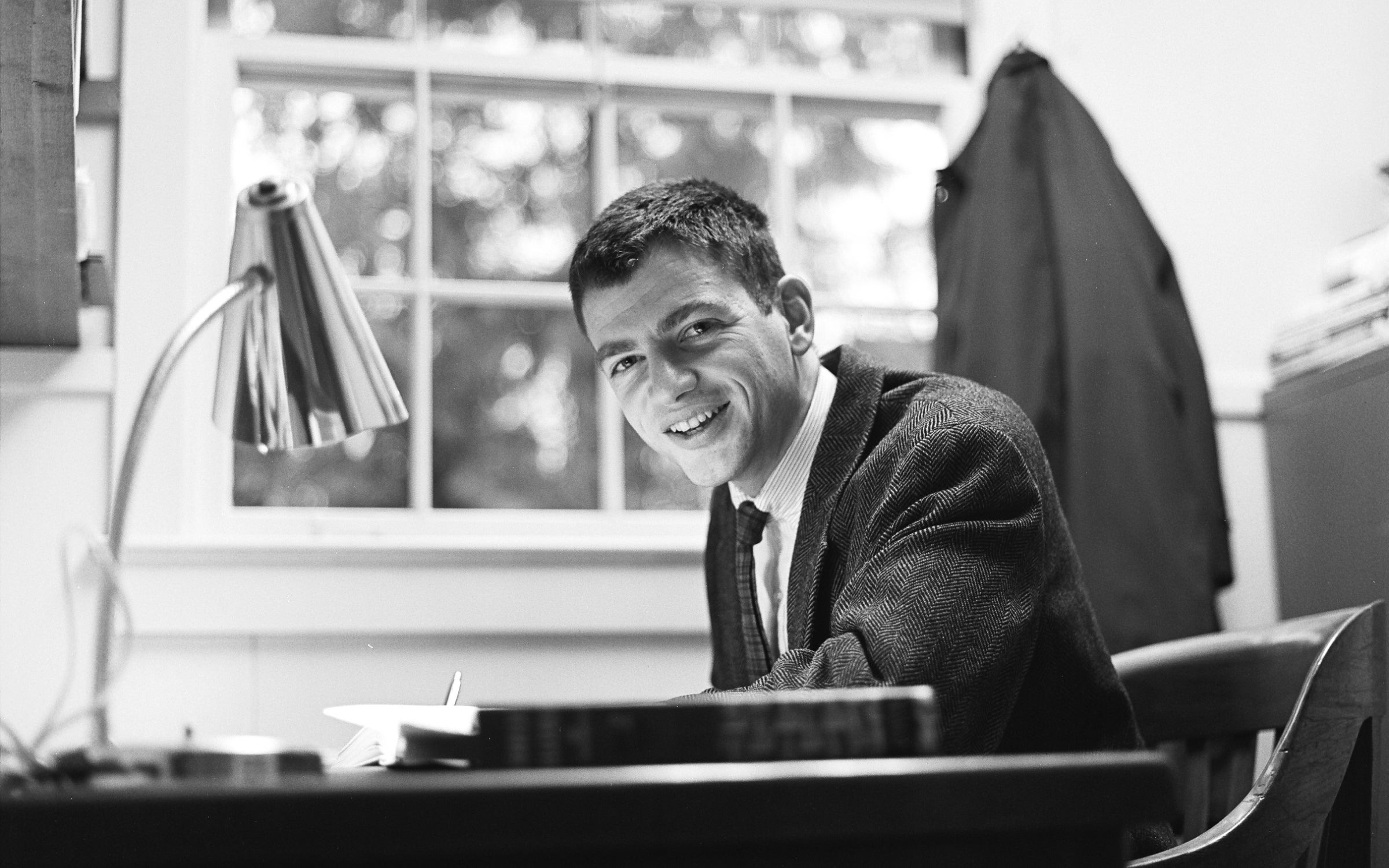 Fred Wright sitting at a desk smiling.