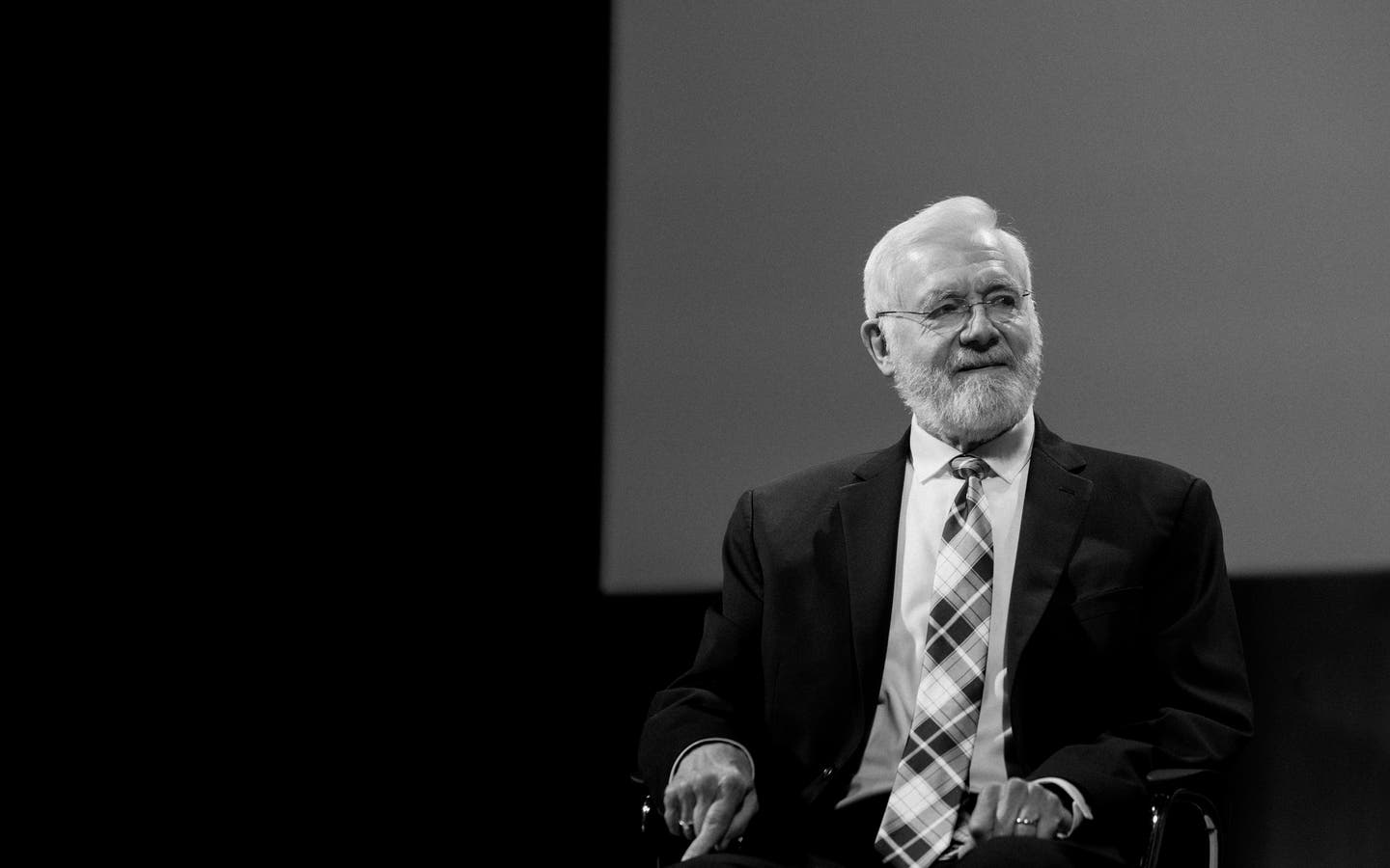 Bill Foege sitting in a chair looking to the side.