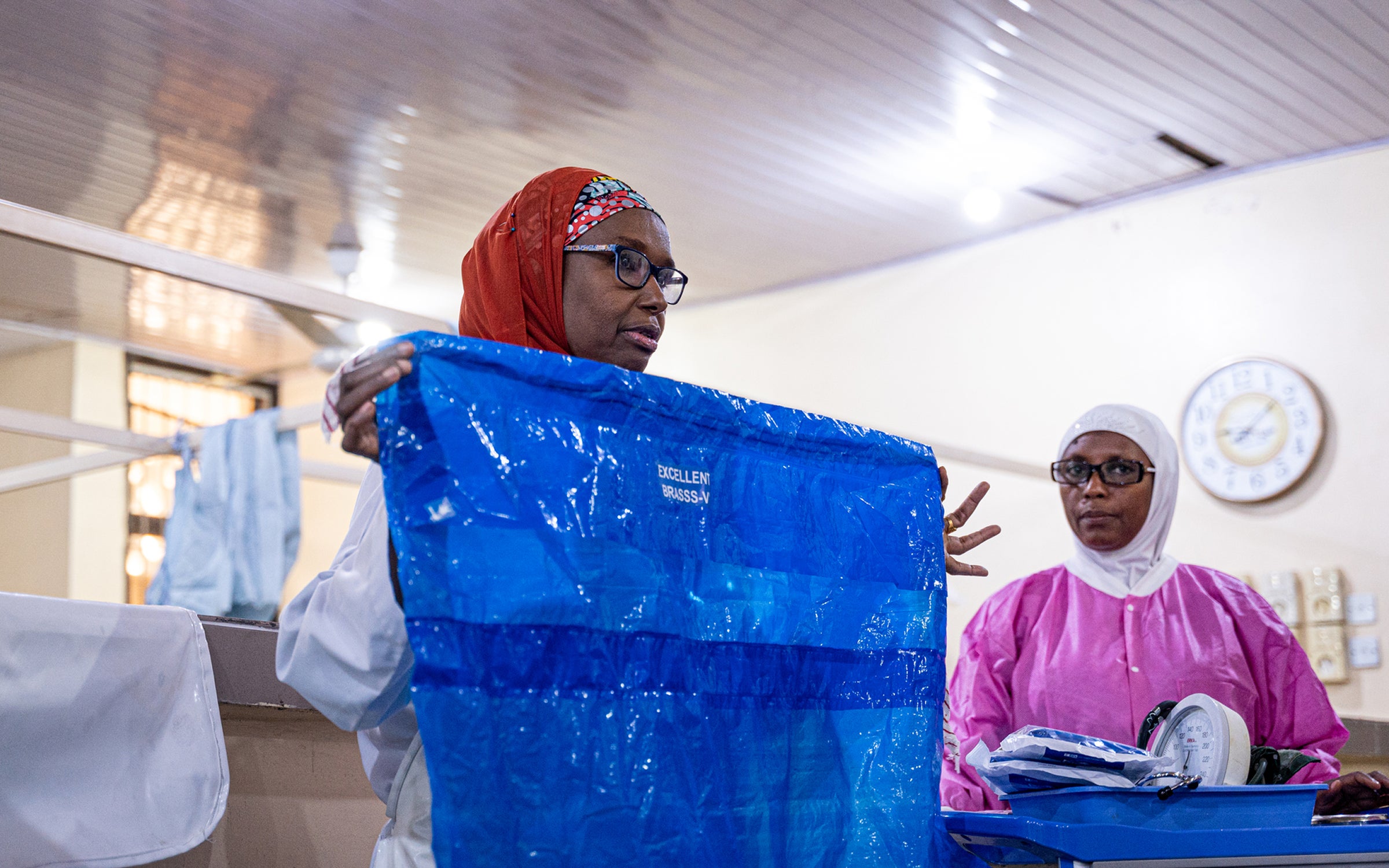 A healthcare worker holds up a calibrated drape used to measure blood loss during childbirth.