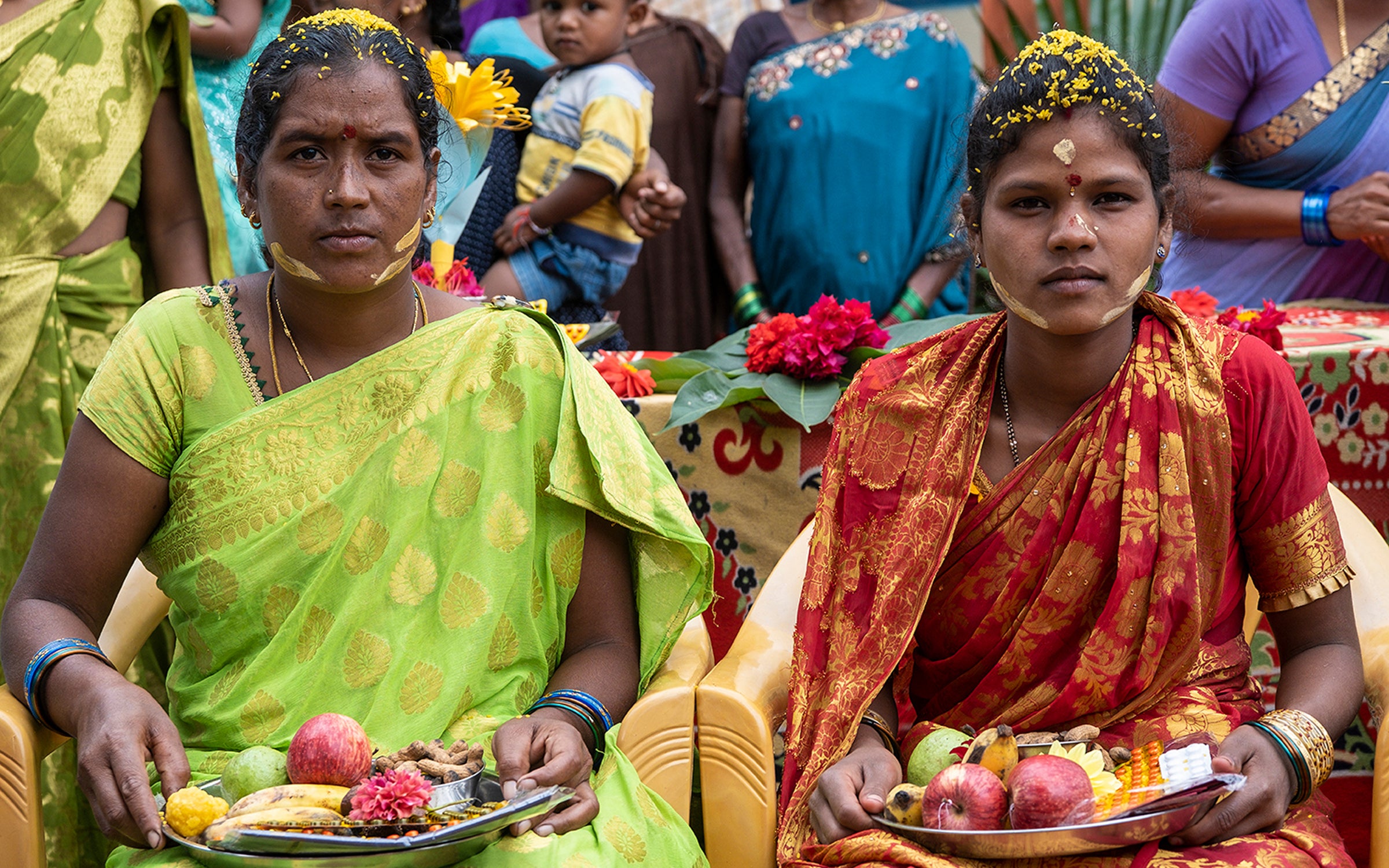Two women in Andhra Pradesh, India hold traditional gifts given to pregnant women.
