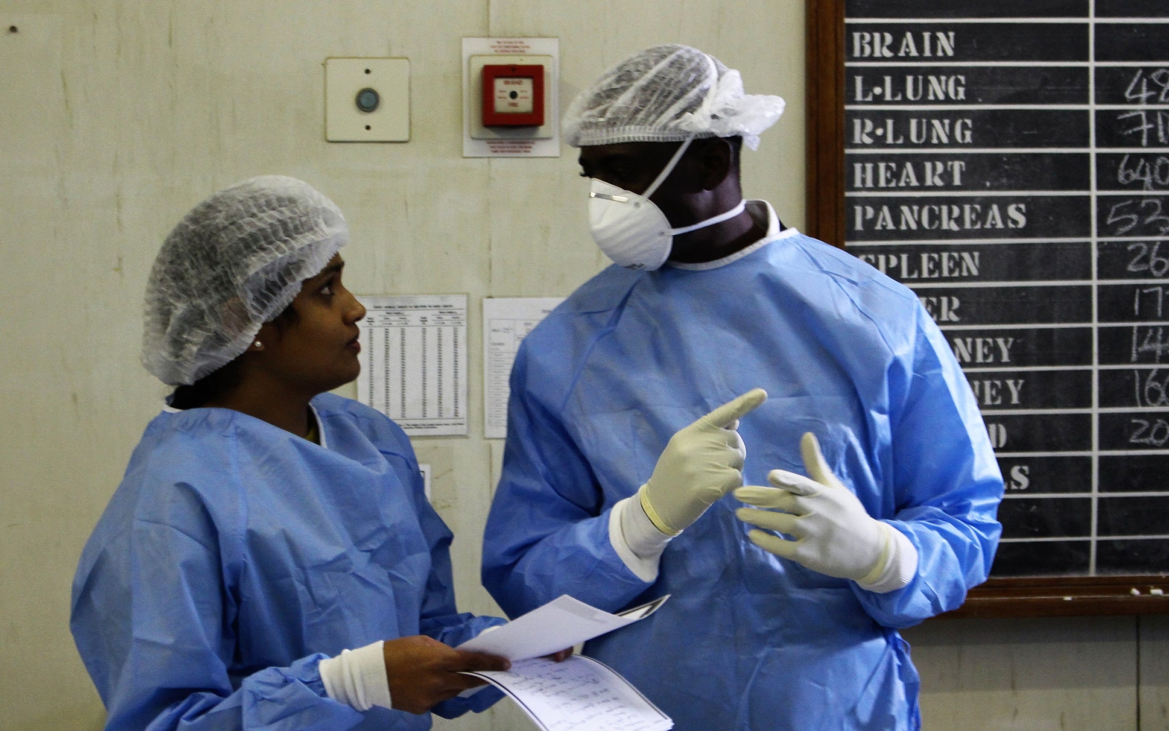 Two healthcare workers in South Africa perform a minimally invasive autopsy alternative through CHAMPS.