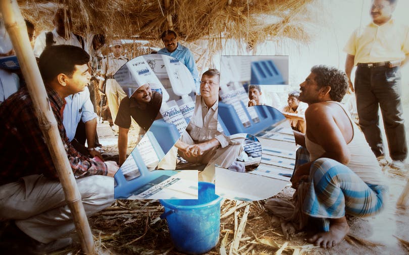 Bill Gates sits and visits with a farmer in a Basa shelter in the Khagaria District in the state of Bihar in India.